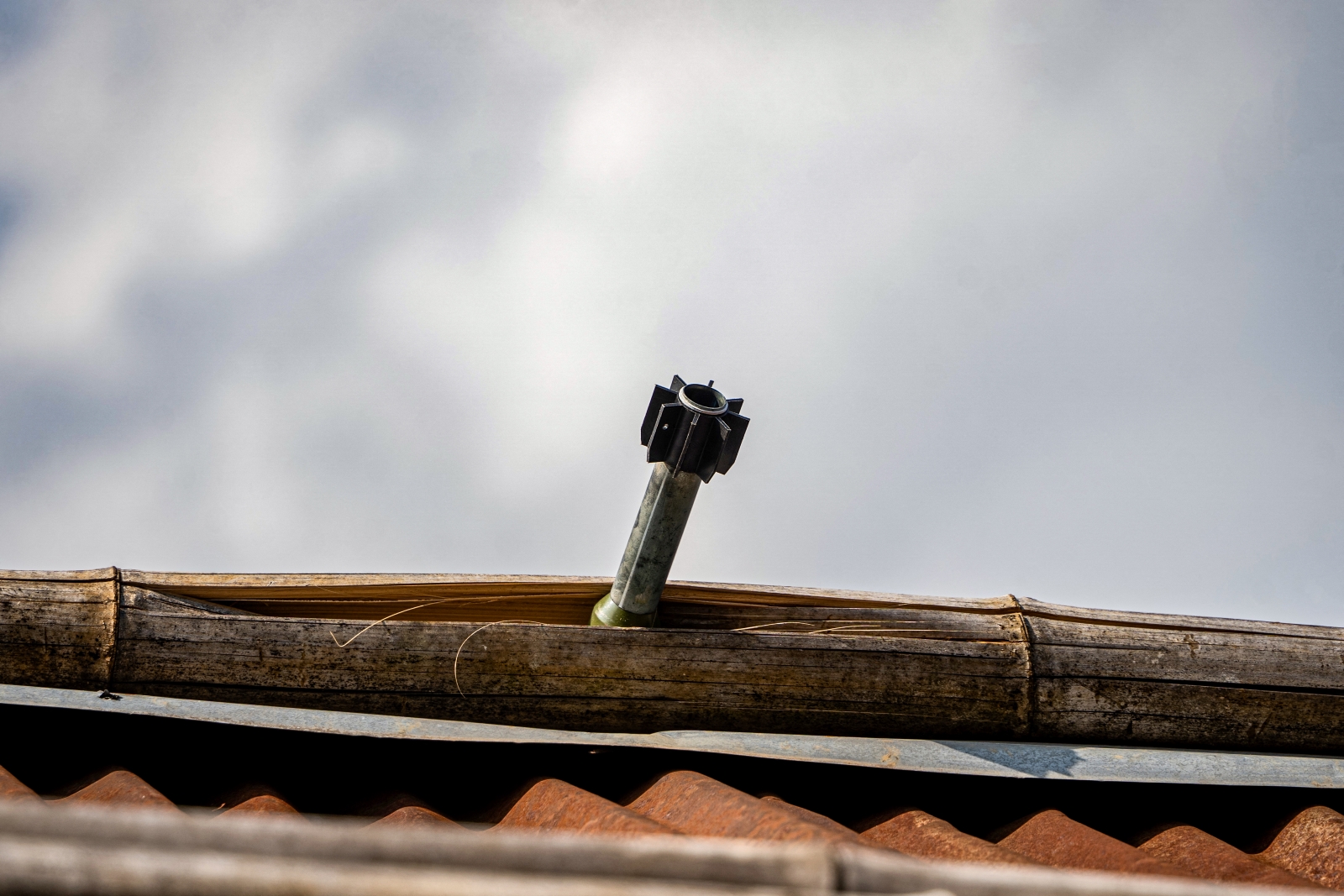 An unexploded projectile stuck on the roof of a house on February 4, following fighting in northern Shan State. (AFP)