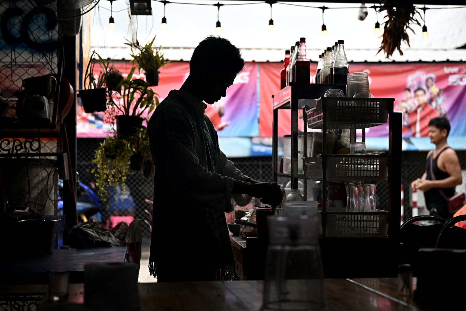 Myanmar former student Wai Yan makes drinks at a Bangkok restaurant on June 4 after fleeing to Thailand to avoid conscription by Myanmar's military junta. (AFP)