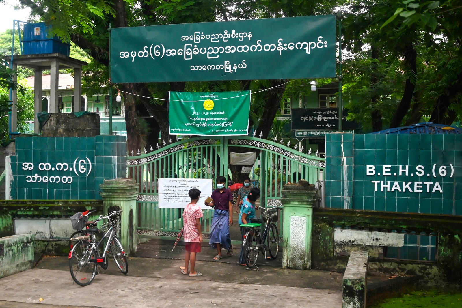 Parents walk out of a school in Yangon after registering their children for the new school year on May 31, 2022. (AFP)