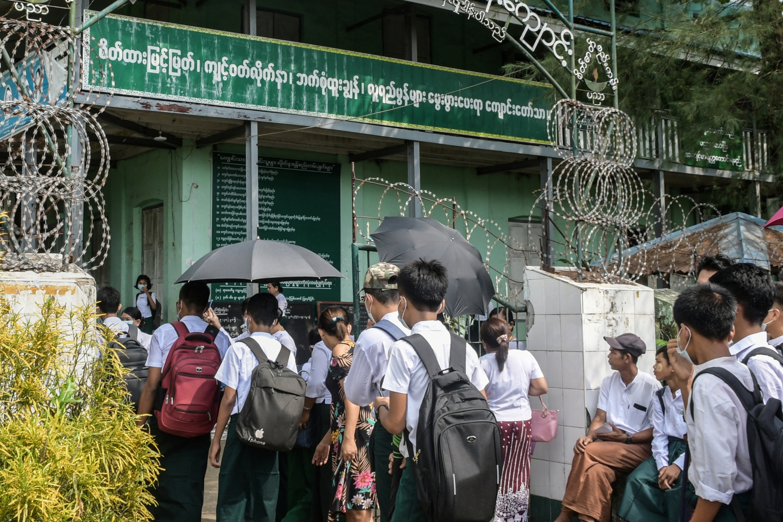 Students wait at a school entrance in the Rakhine State capital Sittwe on June 1, 2021. (AFP)