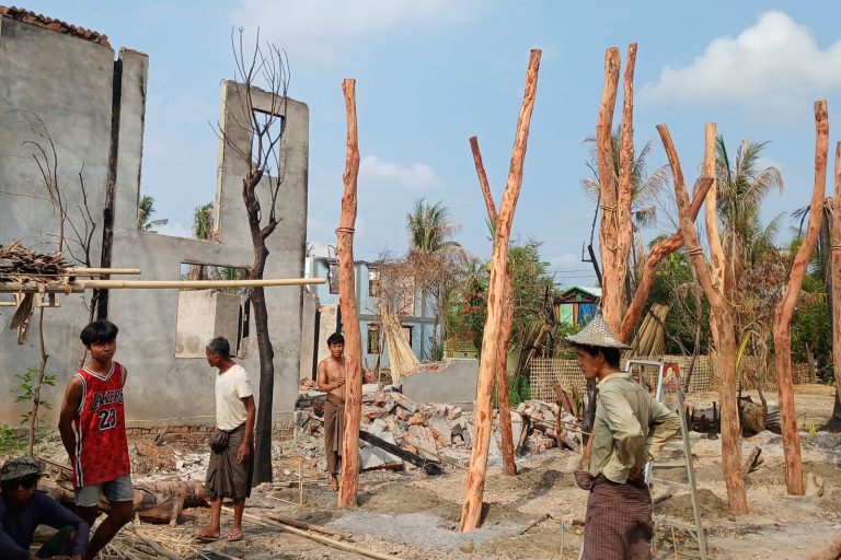 People build temporary homes on May 21 near a building destroyed during clashes between the military and the Arakan Army in a village in Rakhine State’s Minbya Township. (AFP)